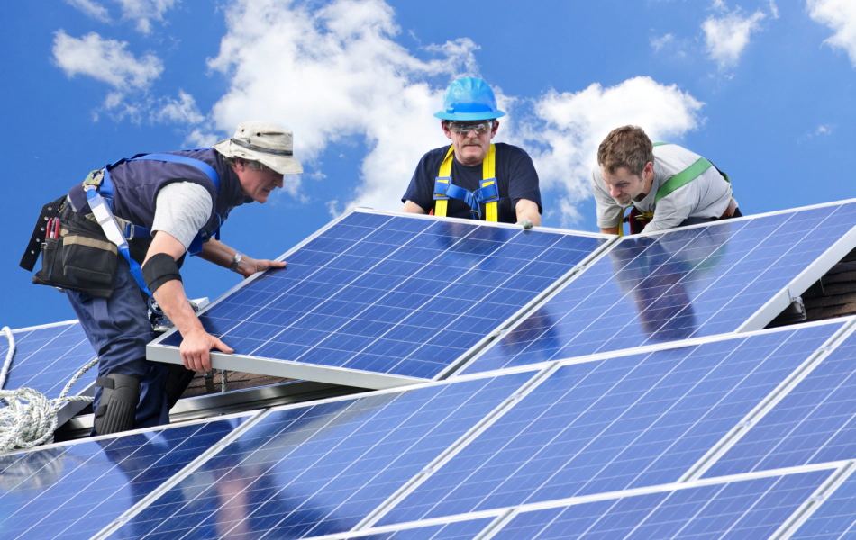 three people installing solar panels